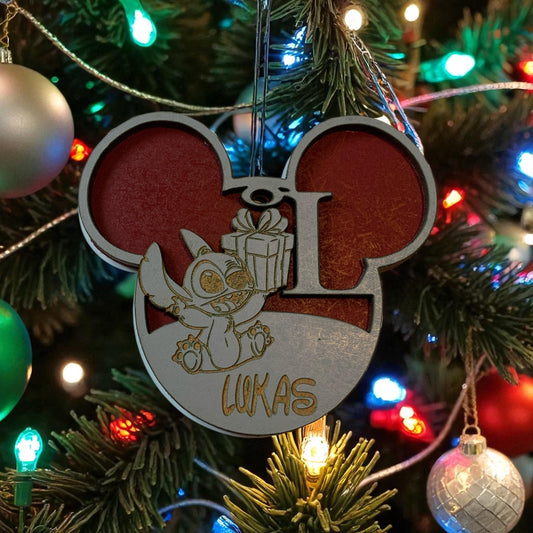 "Boule de Noël en bois Stitch personnalisée suspendue dans un sapin de Noël décoré, montrant la décoration en situation réelle avec guirlandes et lumières"