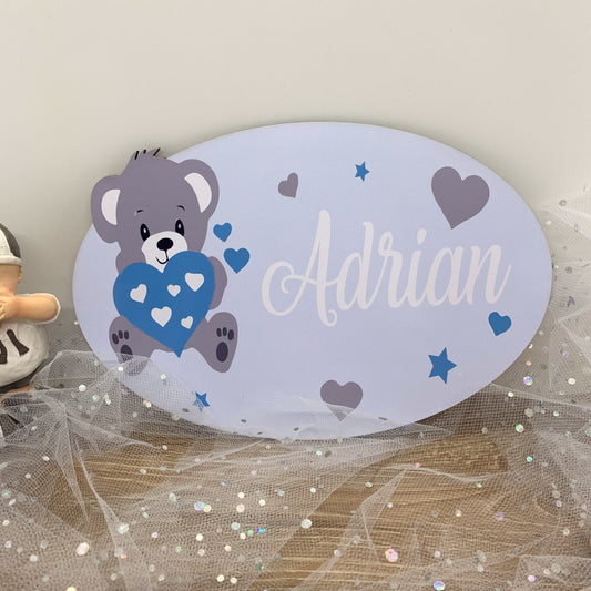 "Plaque de porte bleu ourson personnalisée avec prénom installée dans une chambre d'enfant, montrant la décoration en situation réelle sur porte ou mur"