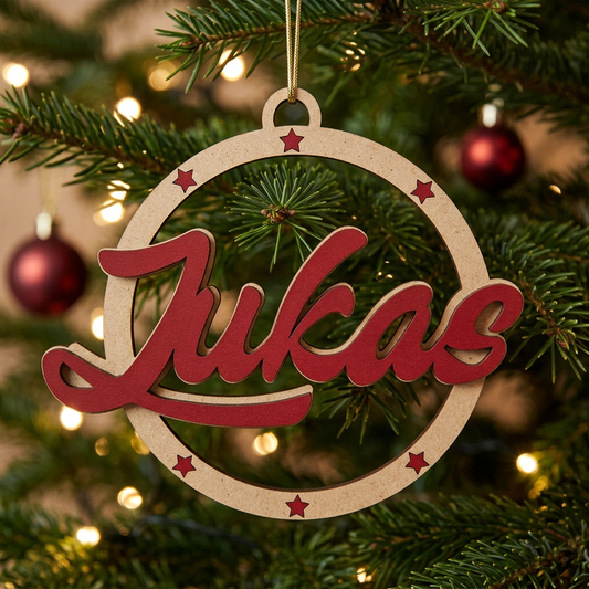 Boule de Noël ajourée en bois naturel avec prénom Lukas et étoiles rouge Noël suspendue dans un sapin illuminé