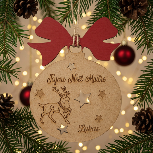 Boule de Noël en bois Joyeux Noël Maître Lukas avec nœud rouge, renne gravé et étoiles ajourées dans un sapin illuminé